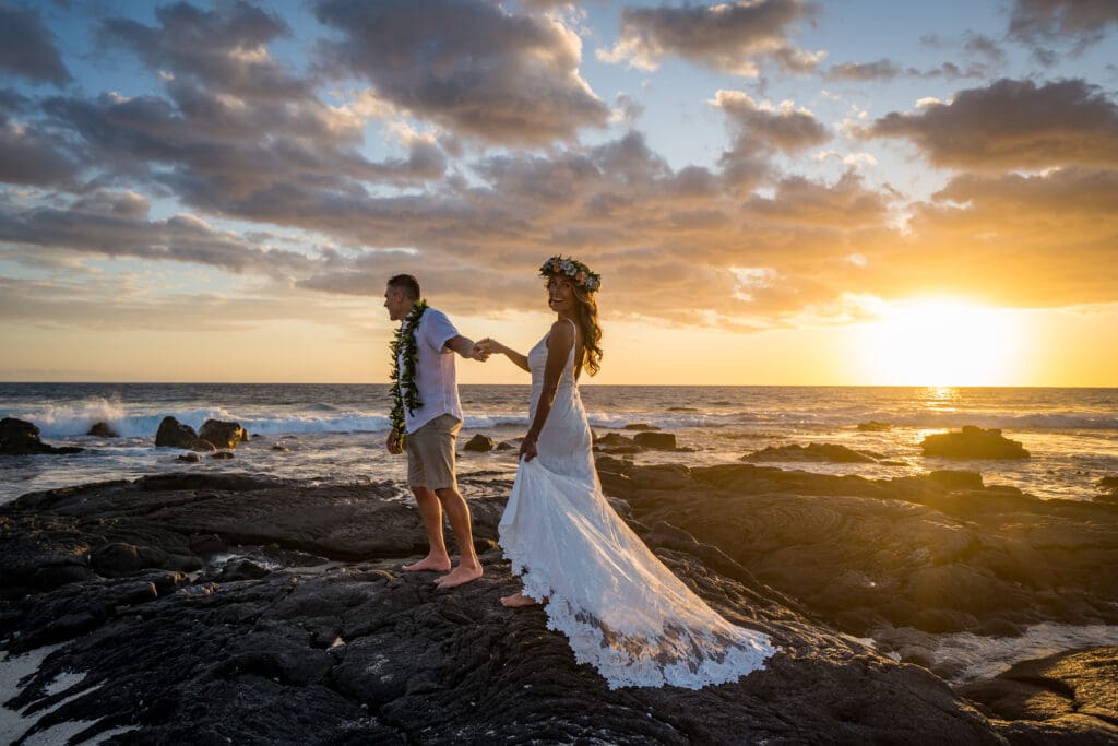 Couple eloping at sunset on lava rock cliffs, Kohanaiki Big Island Hawaii wedding photo