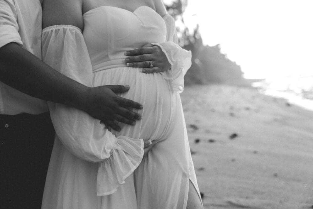 Maternity portrait of couple holding baby bump at Ke'ei Beach, Big Island Hawaii wedding photography