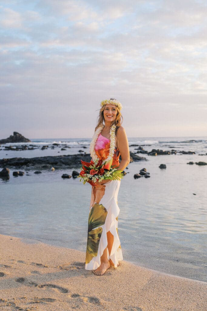 Bride in colorful floral dress posing at Old Airport Beach, Big Island wedding photography