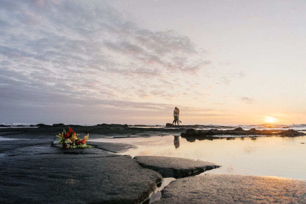 Couple embracing on lava rocks at Old Airport Beach, Kona Hawaii wedding photography