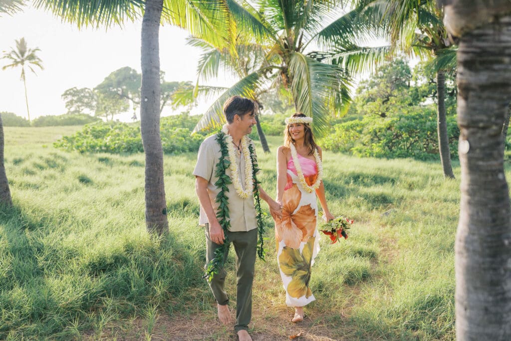 Couple walking along palm trees at Old Airport Beach, Kona Hawaii wedding photography
