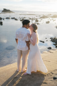 Couple standing together in the ocean at sunset in Kona