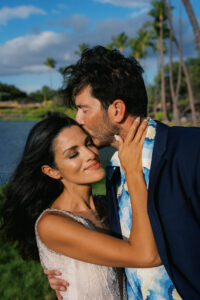 Couple embracing and kissing by the pond at Anaehoʻomalu Bay