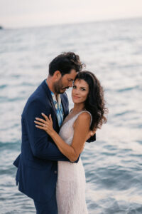 Bride and groom embracing in the water at Anaehoʻomalu Bay