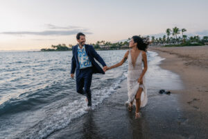 Bride and groom running and laughing on the beach at A-Bay